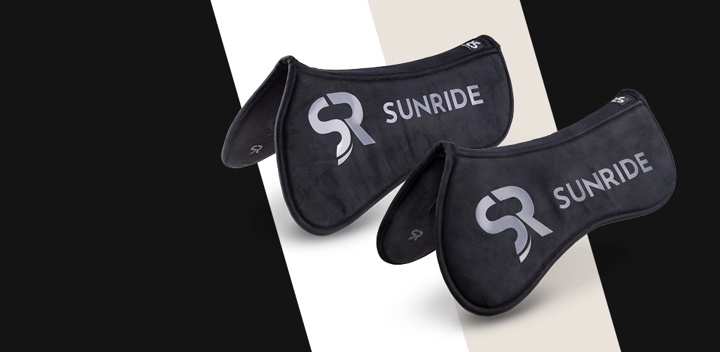 Zwei schwarze Sattelpads mit dem SUNRIDE Logo liegen nebeneinander