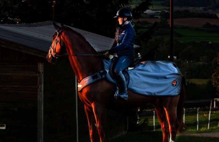 Ein Pferd und Reiter mit der New York LED Ausreitdecke in der Dunkelheit