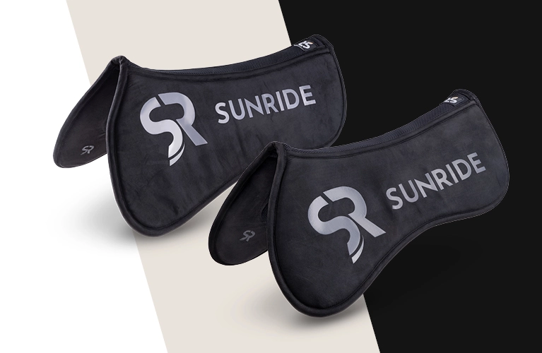 Zwei schwarze Sattelpads mit dem SUNRIDE Logo liegen nebeneinander